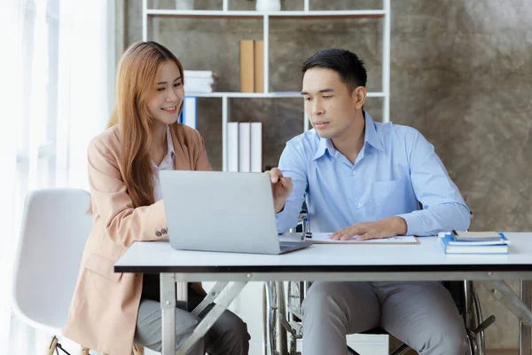 Man sits in a wheelchair and brainstorms with colleagues, conducts business, recruits people with disabilities to work, works with in-house teams and has people with disabilities as part of the team.