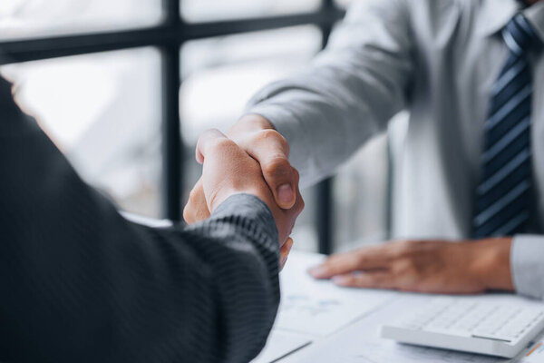 Business investor group holding hands, Two businessmen are agreeing on business together and shaking hands after a successful negotiation. Handshaking is a Western greeting or congratulation.