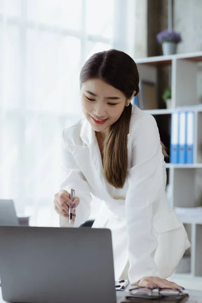 An Asian female employee in the office of a startup company, she is an employee of a startup company's finance and tax department. Concept of corporate finance and tax management.