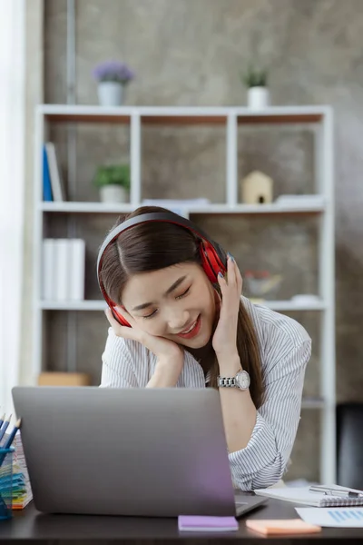 Beautiful woman listening to relaxing music after studying for a long time, she is studying online. The concept of online learning due to the COVID-19 outbreak to prevent an outbreak in the classroom.