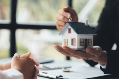 Rental company employee is discussing the details before the customer agrees to sign a rental contract, explaining the details and the terms and conditions of the rental. Real estate rental ideas.