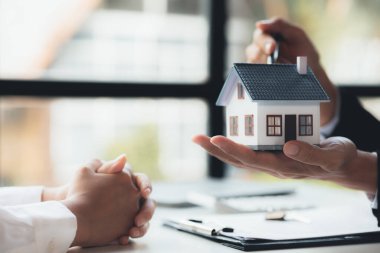 Kiralama şirketi çalışanı, müşteri kira sözleşmesini imzalamadan önce kira sözleşmesinin detaylarını ve şartlarını açıklamadan önce detayları tartışıyor. Emlak kiralama fikirleri.