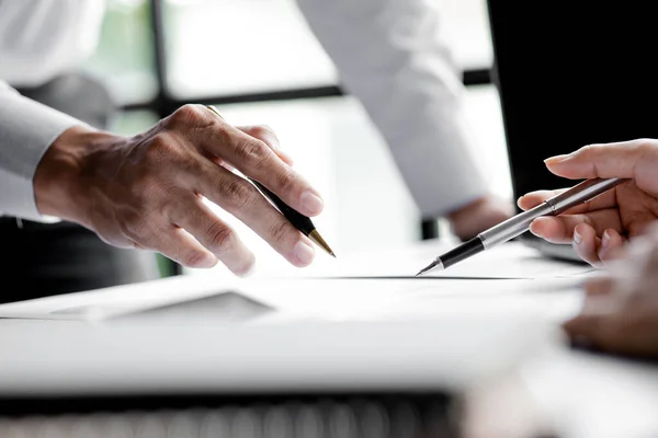 Company meeting room has businessmen and finance managers meeting together on finance topics, they are looking at information on documents and discussing together. Concept company financial management