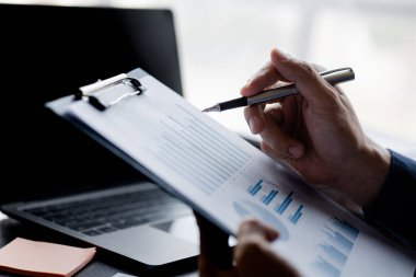 İşadamları, sorunları analiz etmek ve bilgiyi bir ortakla toplantıya getirmeden önce çözüm bulmak için şirketin mali belgelerine bakıyorlar. Mali konsept.