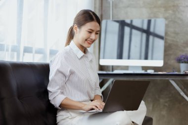 Kadın evdeki oturma odasındaki kanepede dizüstü bilgisayarda oynuyor, yoğun bir günün ardından hafta sonları dinleniyor, film izleyerek ve tabletinde müzik dinleyerek rahatlıyor. Tatil kavramı.