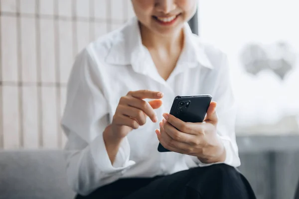 Asian woman using mobile phone, she surfs internet and social media on smartphone, chatting on app with friends. The concept of using technology in communication and the use of the Internet.