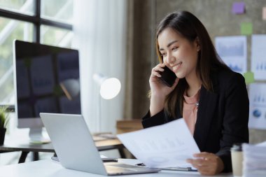 Güzel Asyalı kadın yöneticiler, işletme yöneticileri, pazarlama yöneticileri pazarlama için şirketle iletişime geçmek üzere müşterilerle telefonda konuşuyorlar. Pazarlama yönetimi kavramı.