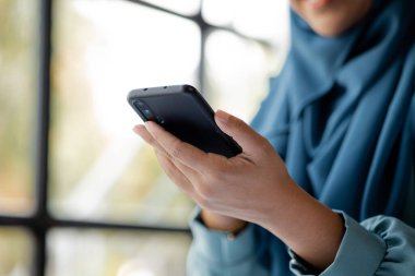 Asian women in hijab are using the mobile phone, administration and operations from the young, smart working women. The management concept drives the company of women leaders to grow.