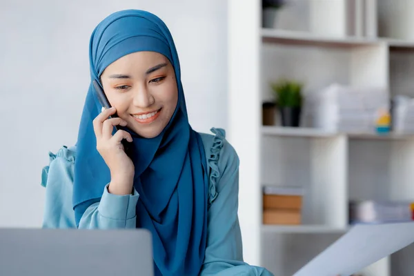 Asian women in hijab are talking on the phone, administration and operations from the new generation, smart working women. The management concept drives the company of women leaders to grow.