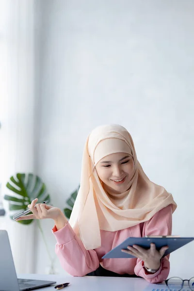 Asian women wearing hijab sitting in the office of a startup company, managed and operated by a young, talented working woman. The management concept drives the company of women leaders to grow.