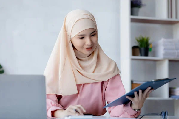 Asian women wearing hijab sitting in the office of a startup company, managed and operated by a young, talented working woman. The management concept drives the company of women leaders to grow.