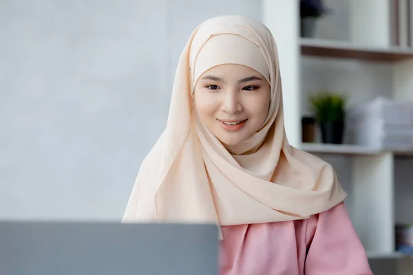 Asian women wearing hijab sitting in the office of a startup company, managed and operated by a young, talented working woman. The management concept drives the company of women leaders to grow.