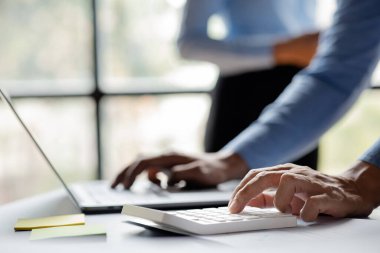 Beyaz hesap makinesi kullanan bir iş adamının yakın plan çekimi, bir şirketin mali dökümanındaki sayısal verileri inceleyen bir finans işadamı, sayıların doğruluğunu doğrulamak için bir hesap makinesi kullanır..