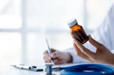 Physicians view diagnostic documents and hold medications in hospital rooms, treating diseases from specialists and providing targeted treatment. Concepts of medical treatment and specialists.