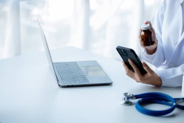 Doctors print reports on smartphones in the hospital's medical room, treating diseases from specialists and providing targeted treatment. Concepts of medical treatment and specialists.