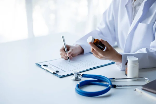 Physicians view diagnostic documents and hold medications in hospital rooms, treating diseases from specialists and providing targeted treatment. Concepts of medical treatment and specialists.