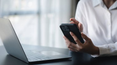 A person is using a smartphone to chat with friends through an application, telecommunication via the Internet on a mobile phone. Concept of using technology in communication.