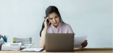 Beautiful Asian woman working with computers in the office of a startup company, she is a company finance employee working in the finance department. Concept of women working in a company.