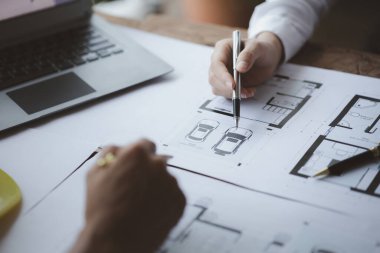 Two architects and engineers are in a meeting to discuss and inspect the house designs to meet the building and construction standards. Interior design and decoration ideas.