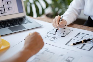 Two architects and engineers are in a meeting to discuss and inspect the house designs to meet the building and construction standards. Interior design and decoration ideas.