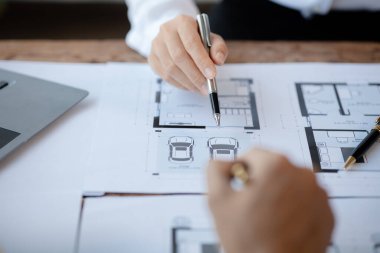 Two architects and engineers are in a meeting to discuss and inspect the house designs to meet the building and construction standards. Interior design and decoration ideas.