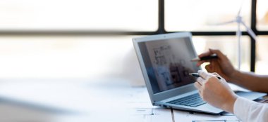 Two architects and engineers are in a meeting to discuss and inspect the house designs to meet the building and construction standards. Interior design and decoration ideas.