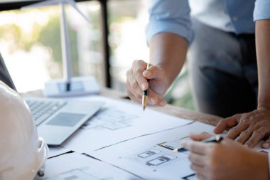 Two architects and engineers are in a meeting to discuss and inspect the house designs to meet the building and construction standards. Interior design and decoration ideas.