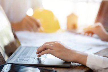 Two architects and engineers are in a meeting to discuss and inspect the house designs to meet the building and construction standards. Interior design and decoration ideas.