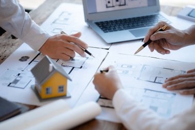 Architects and engineers are working together to edit the draft house plan that was designed after it was presented to the client and partially revised the design. Interior design and decoration ideas