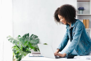 American woman sits in the white office of a startup company, she is a company employee, young generation operations run the company with the concept of the new generation. Company management concept
