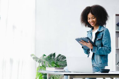 American woman sits in the white office of a startup company, she is a company employee, young generation operations run the company with the concept of the new generation. Company management concept
