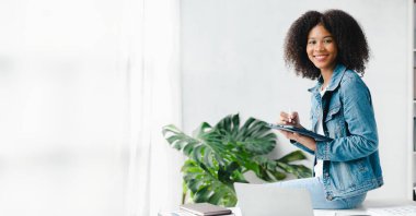 American woman sits in the white office of a startup company, she is a company employee, young generation operations run the company with the concept of the new generation. Company management concept