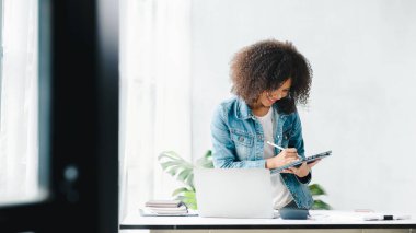American woman sits in the white office of a startup company, she is a company employee, young generation operations run the company with the concept of the new generation. Company management concept