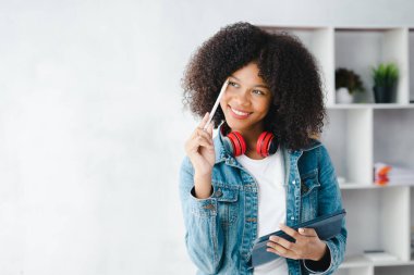 Beyaz odadaki Amerikalı kadın, o bir üniversite öğrencisi, evinde online çalışıyor, videoyla çalışıyor ve ev ödevlerini yapıyor. İnternet 'te okuyan öğrenciler konsepti.