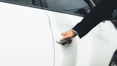 İşe gitmek için araba kapısı açan bir adam, yolda güvenli bir şekilde seyahat etmek ve trafik kurallarına uymak için araçları kullanıyor. Güvenli sürüş kavramı.