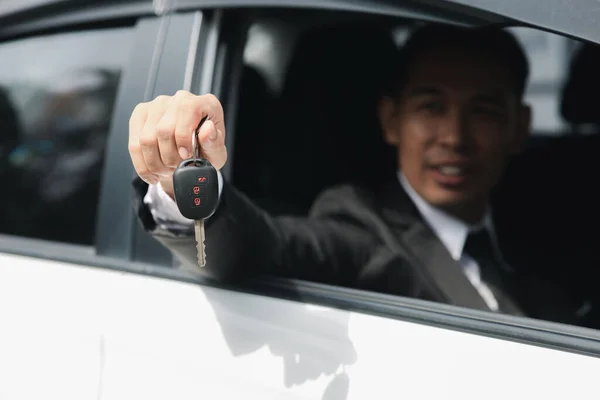 車に座って 車のキーを押し 車で移動し 安全運転し 交通ルールを尊重する正式なスーツのアジア人男性 — ストック写真