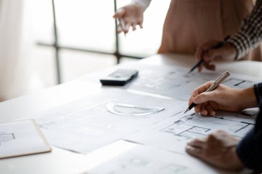 Architects and engineers are working together to edit the draft house plan that was designed after it was presented to the client and partially revised the design. Interior design and decoration ideas