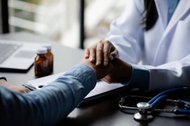 Doctor shook hands to encourage the patient after informing the results of the examination and informing the patients about treatment guidelines and prescribing medicines. Disease examination concept.