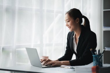 Bir iş kadını şirketin mali belgelerini kontrol ediyor ve bir mesajlaşma programı aracılığıyla finans müdürüyle konuşmak için tablet kullanıyor. Şirket mali yönetimi kavramı.