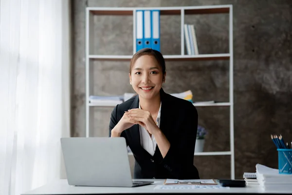 A businesswoman is checking company financial documents and using a tablet to talk to the chief financial officer through a messaging program. Concept of company financial management.