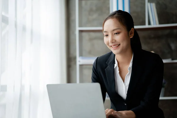 A businesswoman is checking company financial documents and using a tablet to talk to the chief financial officer through a messaging program. Concept of company financial management.