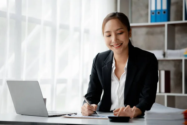 A businesswoman is checking company financial documents and using a tablet to talk to the chief financial officer through a messaging program. Concept of company financial management.