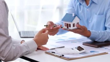 Real estate agents explain models of housing estates in projects to elaborate to clients, explaining and presenting information about homes and purchasing loans. Real estate trading concept.