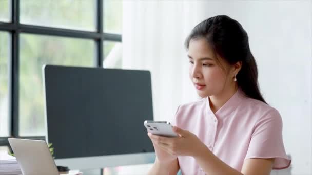 漂亮的亚洲女人在休息的时候玩手机 她是一家初创公司的营销经理 女性领导 妇女领导概念 — 图库视频影像