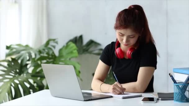 这个美丽的亚洲女人是一名大学生 她正在通过笔记本电脑和同学们视频通话 讨论一个联合课程的小组工作 利用技术进行交流的概念 — 图库视频影像