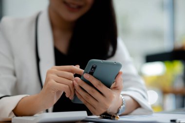 İşe ara verdiğinde cep telefonuyla oynayan güzel bir Asyalı kadın. Yeni başlayan bir şirketin pazarlama müdürü, kadın lider, yönetici ve CEO 'su. Kadın Liderlik Konsepti.