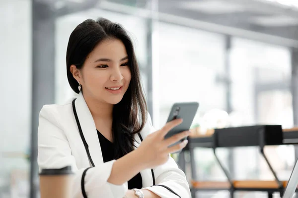 漂亮的亚洲女人在休息的时候玩手机 她是一家初创公司的营销经理 女性领导 妇女领导概念 — 图库照片