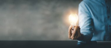 Standing woman holding glowing lamp, Creative new idea. Innovation, brainstorming, strategizing to make the business grow and be profitable. Concept execution, strategy planning and profit management.