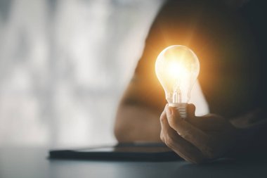 Elinde parlak bir lamba tutan kadın, yaratıcı yeni bir fikir. Yenilik, beyin fırtınası, işi büyütmek ve kâr etmek için strateji geliştirme. Uygulamayı, strateji planlamasını ve kâr yönetimini kabul et.