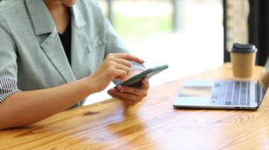 Cep telefonundan mali bilgilere bakan genç bir iş kadını, şirketin mali belgelerini kontrol ediyor, yeni kurulan bir şirketin kadın yöneticisidir. Mali yönetim kavramı.